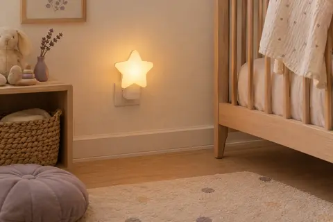 Veilleuse murale Tigex en forme d’étoile blanche, branchée dans une chambre de bébé.